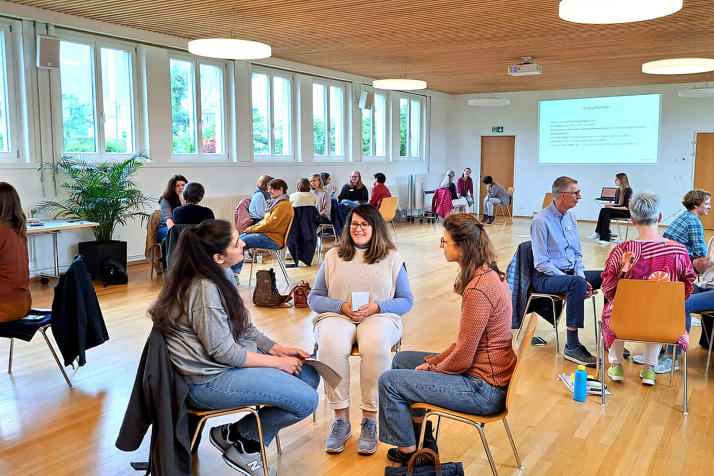 Gewaltfreie-Kommunikation-Weiterbildung-1 Weiterbildung in Gewaltfreier Kommunikation. Gruppe von Menschen machen eine Übung.