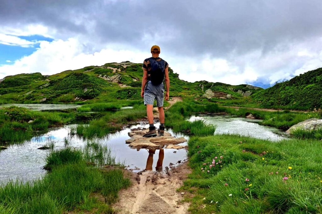 3-Monate-Mentoring Ein Wanderer steht auf einem Berg und schaut in die Ferne.